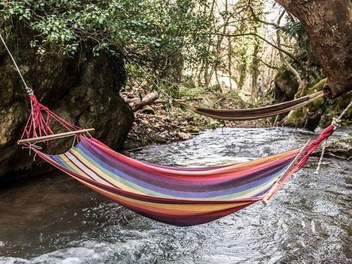 Colorful hammocks over a stream in Pavliani village, Oiti National Park, Greece